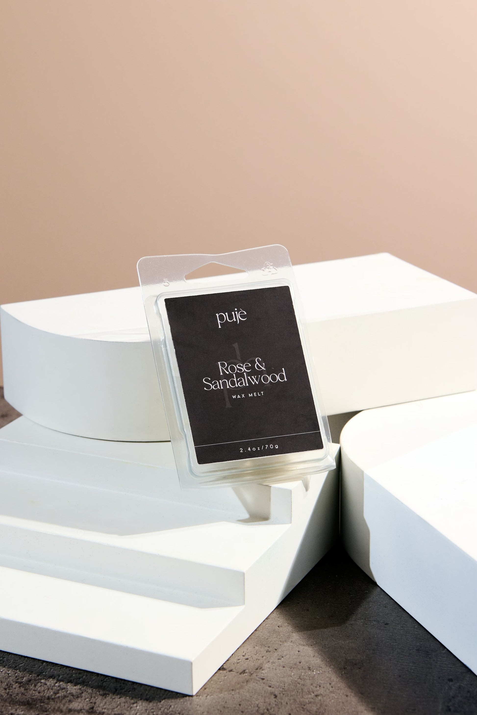 A soy wax melt with a black label that reads "Rose & Sandalwood" Scented.