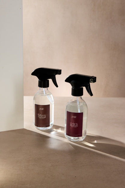 Two Room Sprays in  PET bottles. 
 One with a Burgundy label that reads " Cedar & Rhubarb" scented  and another with a brown label that reads " Saffron & Patchouli " scented.