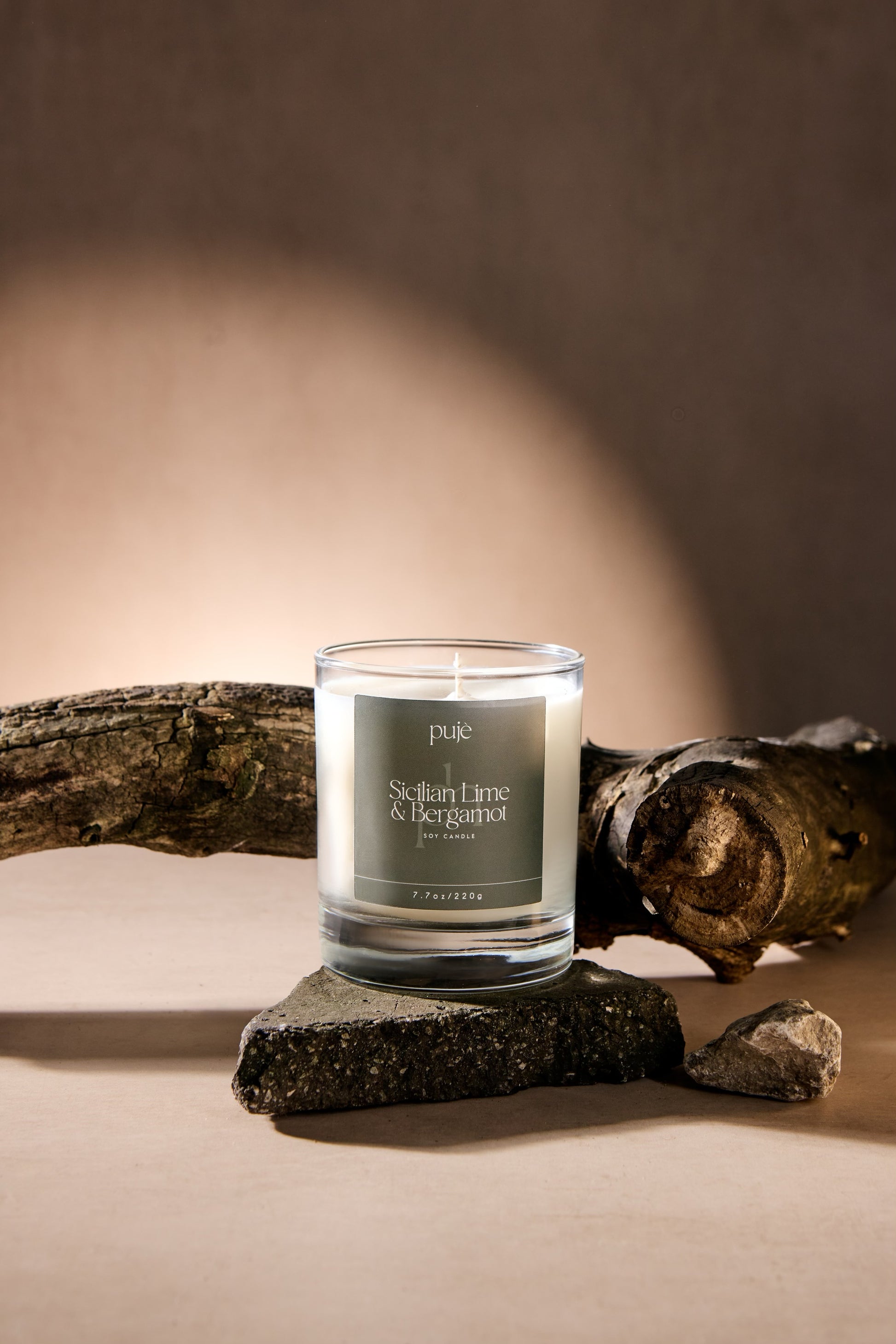 A glass soy wax candle with a green label that reads "Sicilian Lime & Bergamot" Scented.